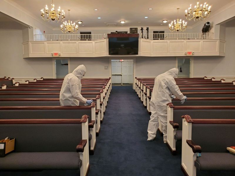 Disinfecting sanctuary pews in protective suits