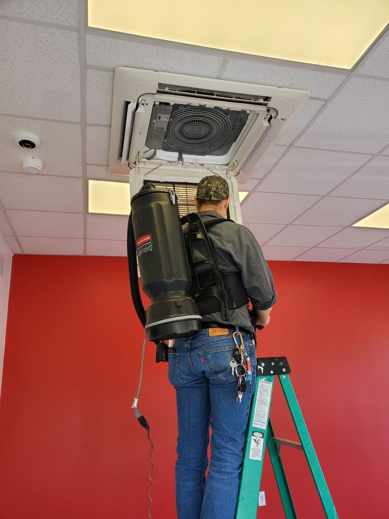 Vacuuming a ceiling HVAC vent